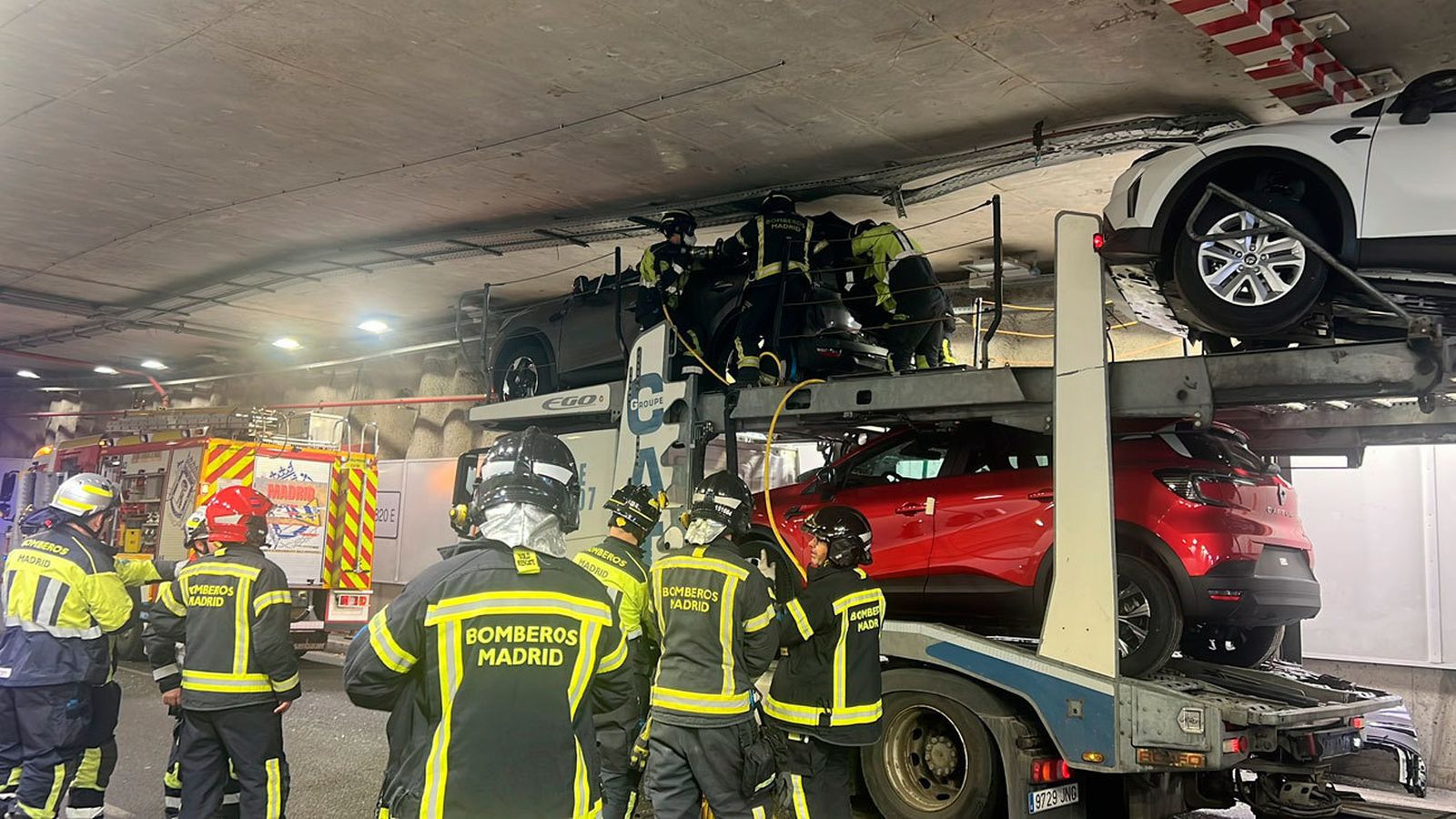 Bomberos de Madrid trabajan para liberar un trailer cargado de coches atrapado en el túnel de Bailén