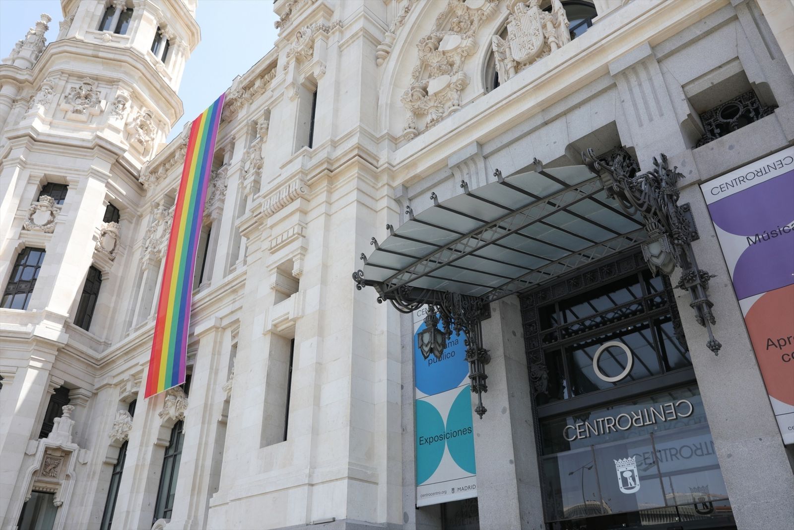Bandera LGTBI colocada en la parte izquierda de la fachada del Palacio de Cibeles, sede del Ayuntamiento de Madrid