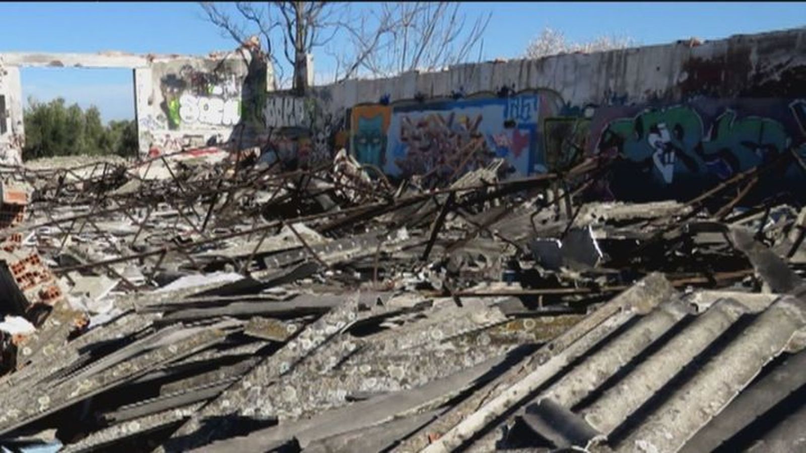 Nave en ruinas con restos de techos de uralita derrumbados