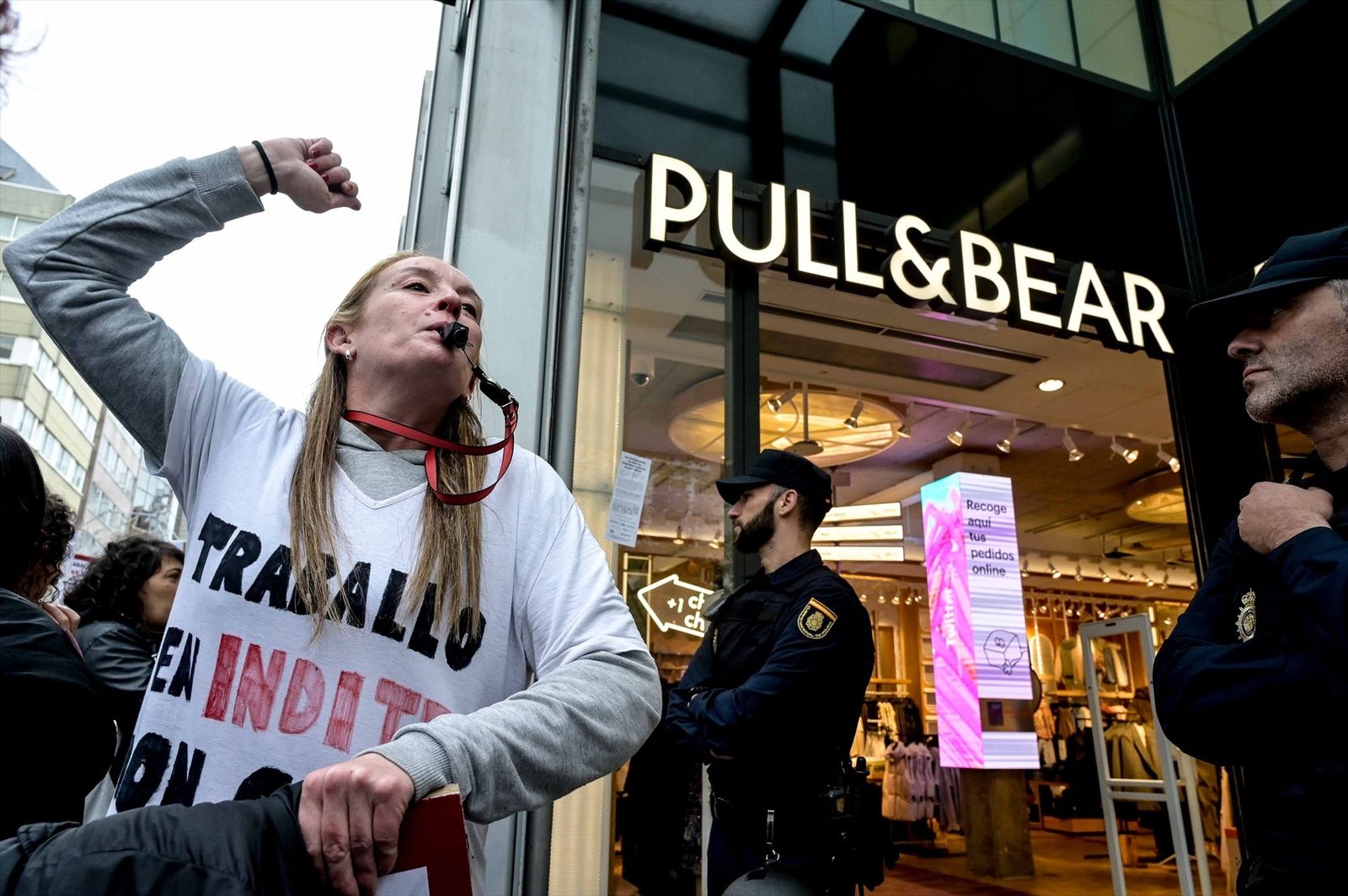Una mujer se manifiesta frente a una tienda Pull & Bear por una subida salarial