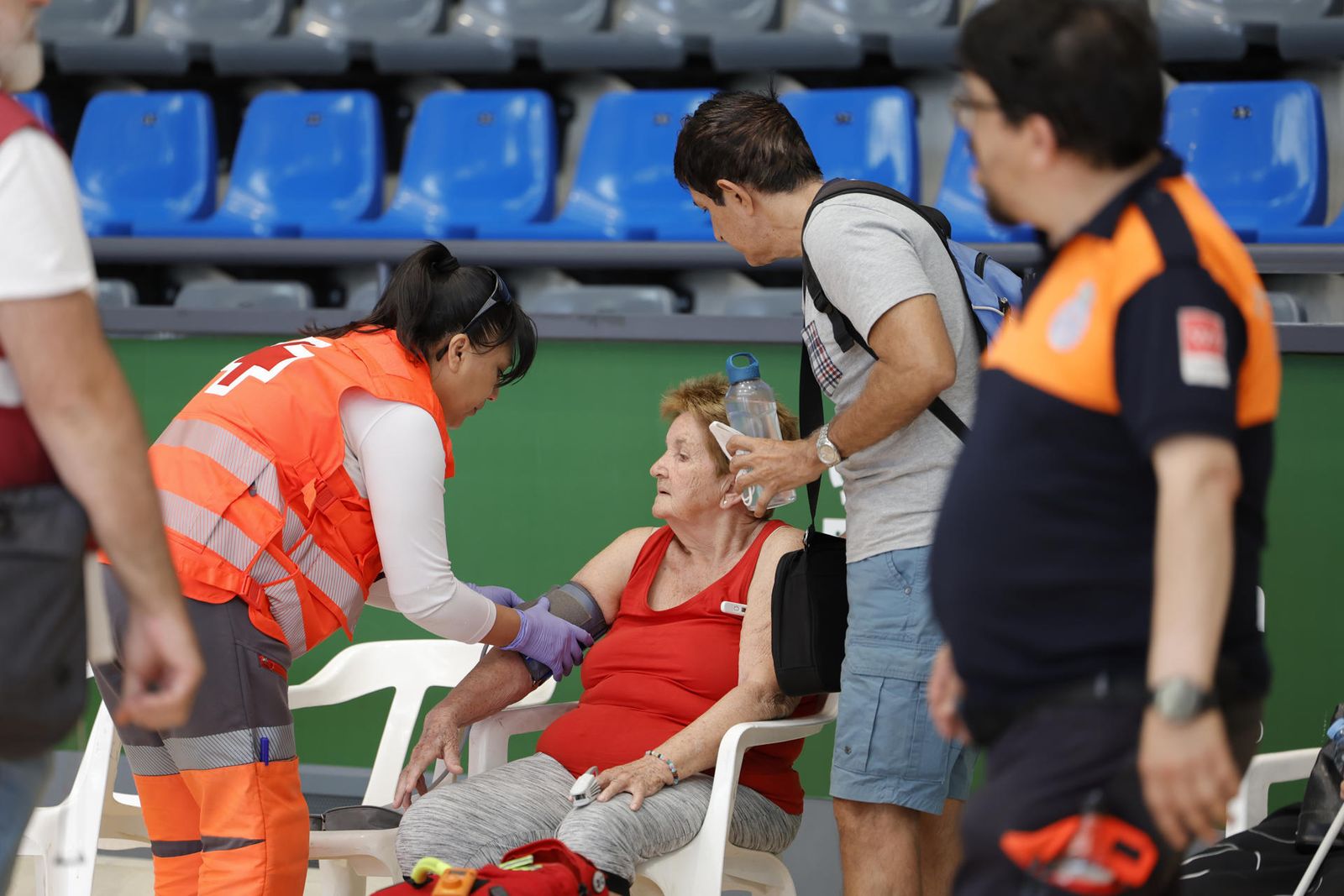 Una integrante de la Cruz Roja ayuda a una mujer evacuada por el incendio de la sierra Oeste