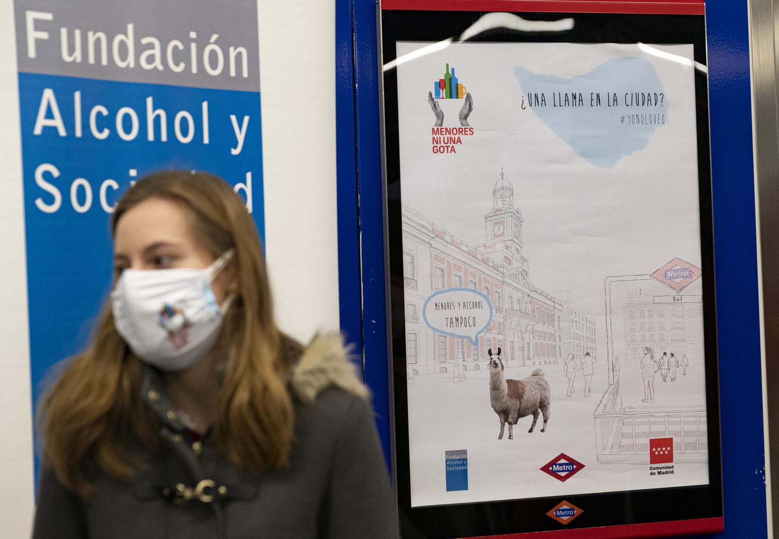 Una de las autoras de la campaña publicitara junto al cartel de la iniciativa de prevención