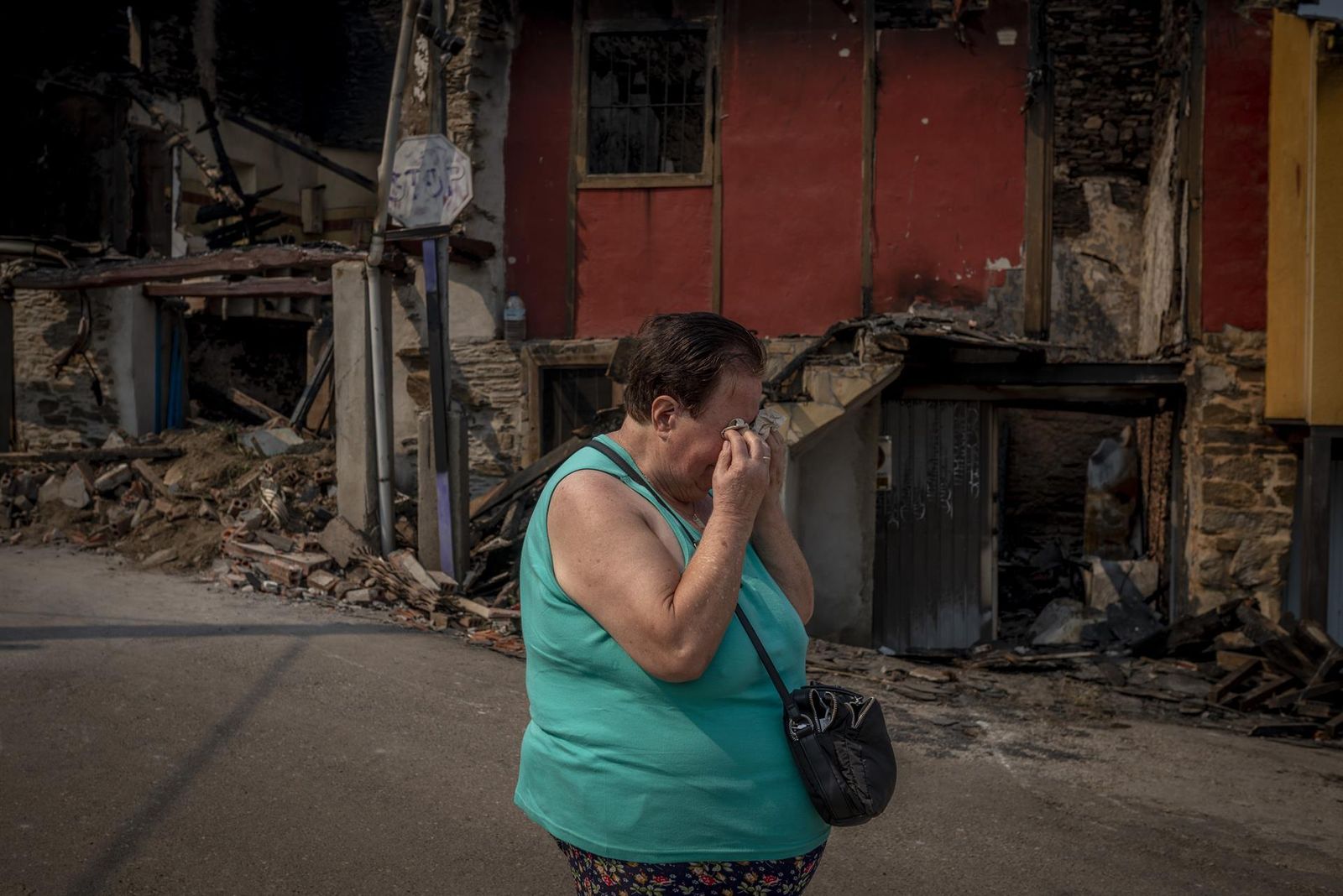 Raquel Borrajo, de 76 años, llora ante su casa quemada durante el incendio forestal acontecido en el pueblo de Alixo (O Barco de Valdeorras), en Ourense,
