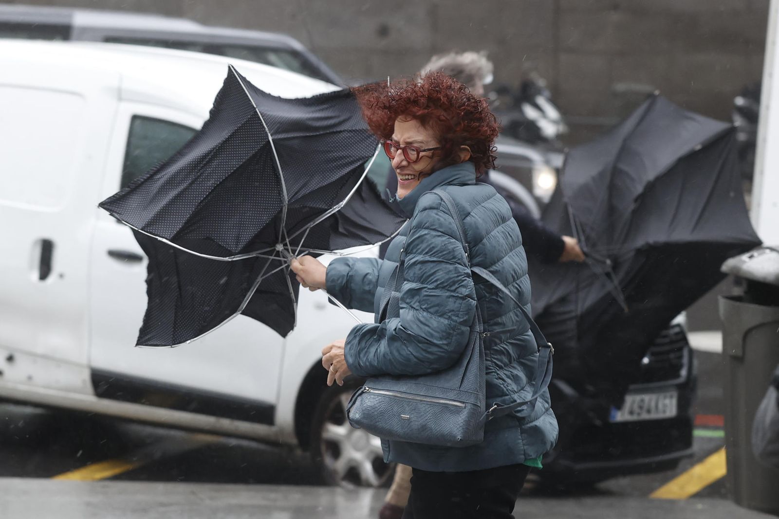 Una viandante se enfrenta a las fuertes rachas de viento