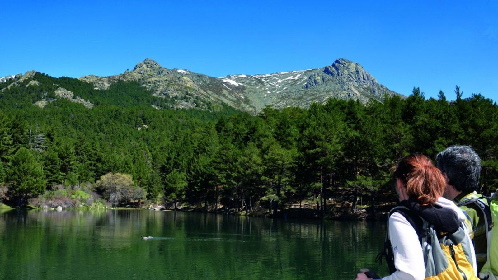 Dos personas contemplan el paisaje de la Sierra de Guadarrama