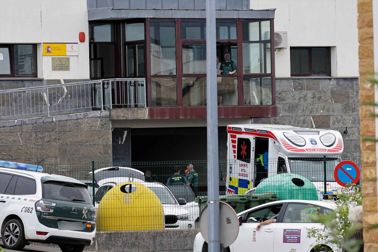 Varios agentes de la guardia cilvil y una ambulancia UVI móvil, en la puerta de entrada del cuartel de la guardia civil de Llanes, Asturias