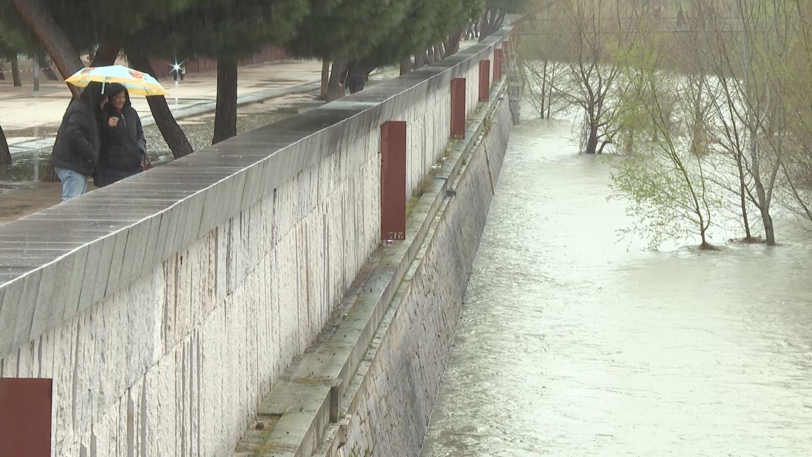 Dos personas observan el río Manzanares