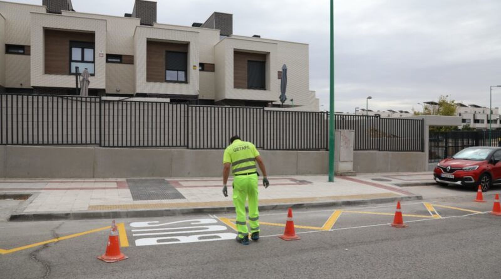 Un operario marca en el asfalto una parada de autobús en Getafe