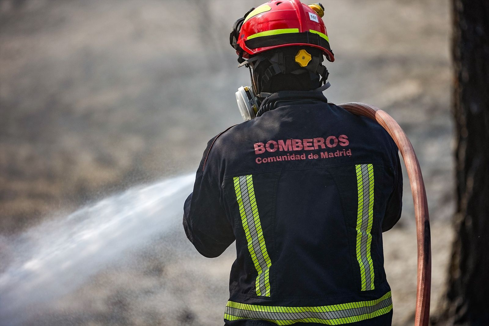 Un bombero de la Comunidad de Madrid sujeta una manguera para extinguir un incendio