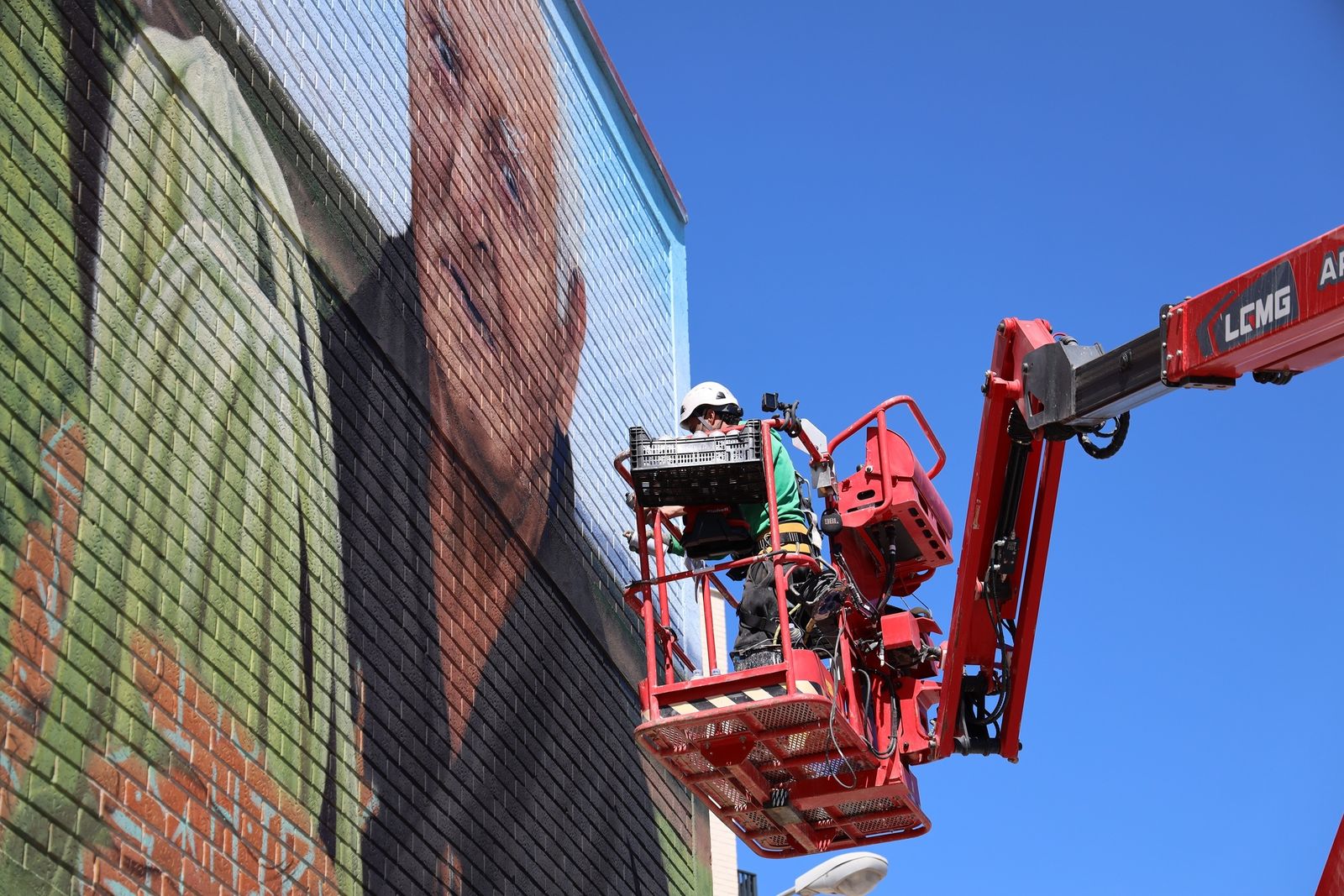 El artista Christian Sasa, durante la elaboración del mural 'Manos de Acero' en Fuenlabrada