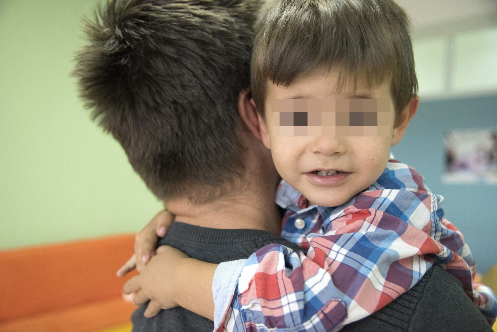 Menor en brazos de su padre de acogida