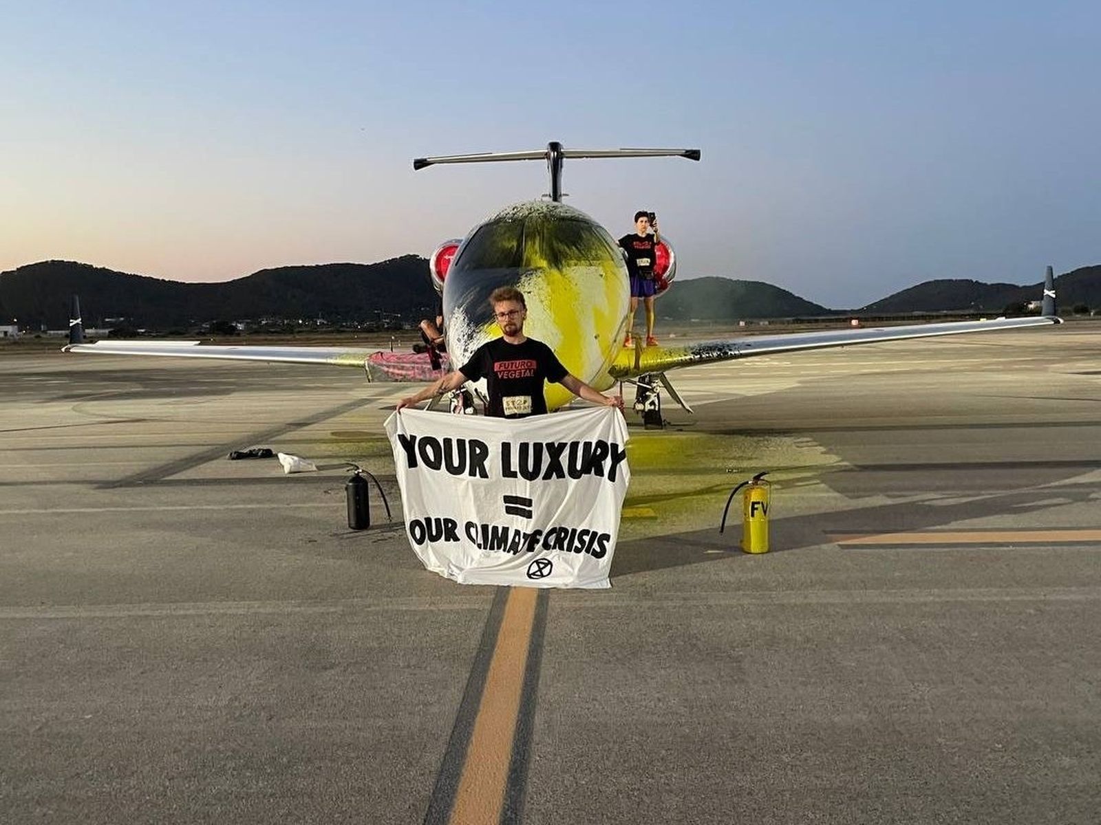 Tres activistas de Futuro Vegetal rocían con pintura y se pegan a un jet privado en el aeropuerto de Ibiza, Islas Baleares.