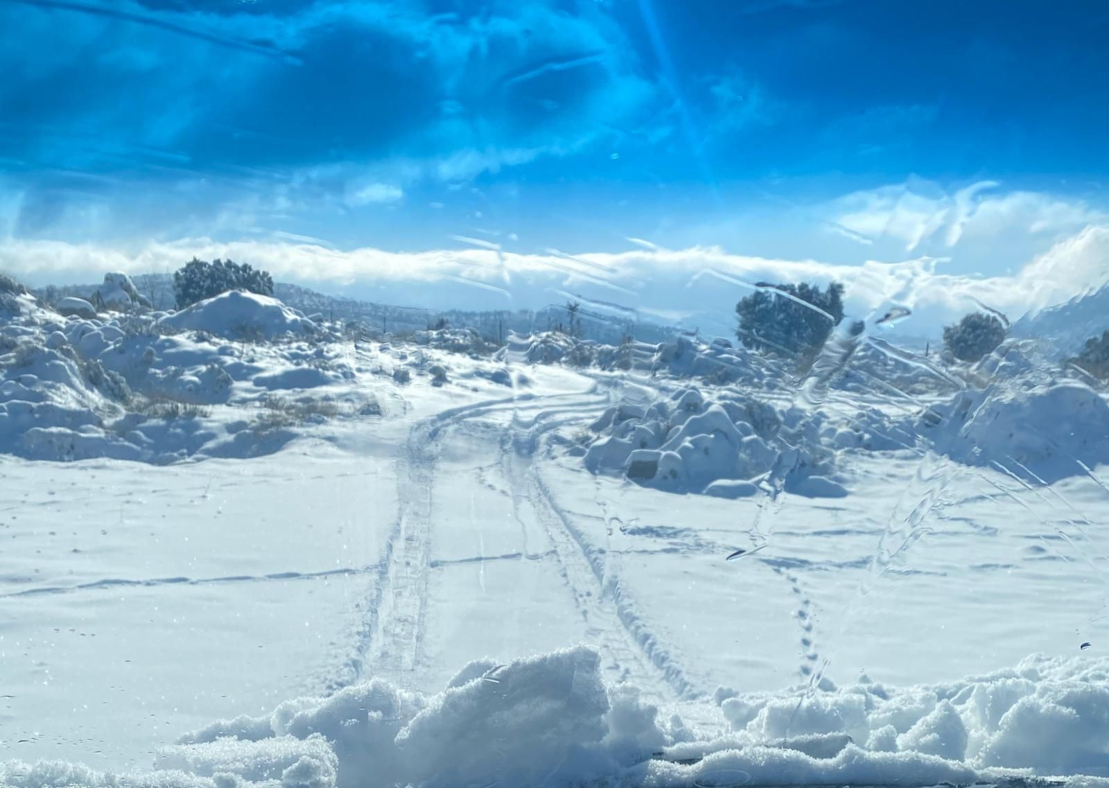 Un vecino de El Molar retira con una excavadora la nieve que mantiene incomunicadas varias fincas