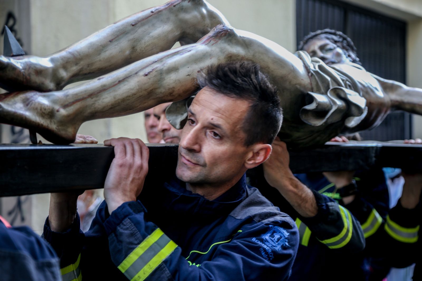 Bomberos llevan la imagen de Cristo en la cruz en la procesión del Cristo de los Niños