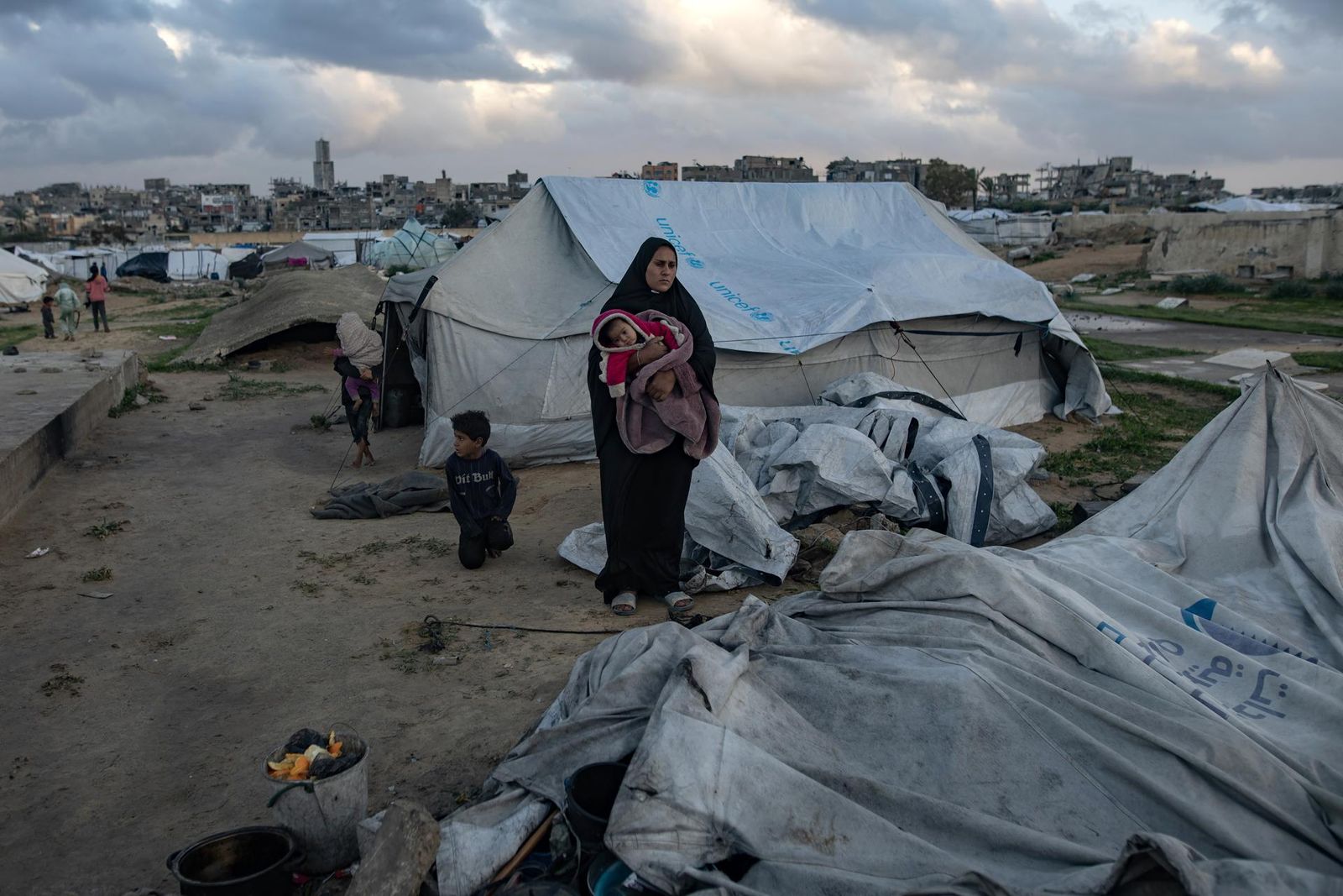 Una familia, ante su tienda tumbada por el temporal, en  Khan Younis, Franja de Gaza