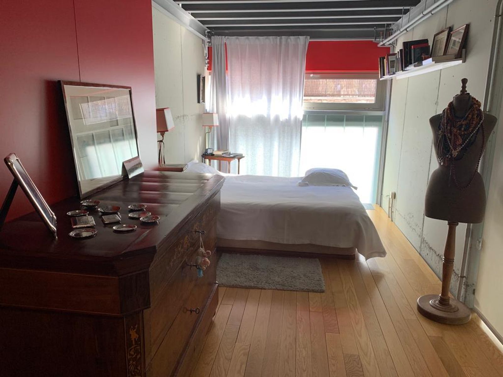 Un detalle de la habitación, que apuesta por el color rojo para contrastar el frío del acero.