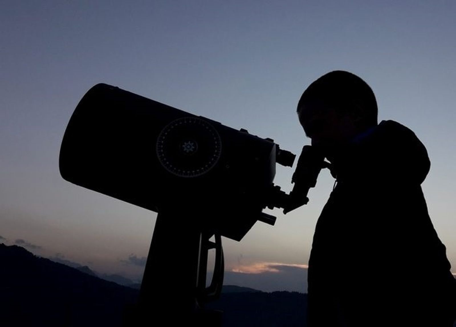 Una persona mira a través del ocular de un telescopio