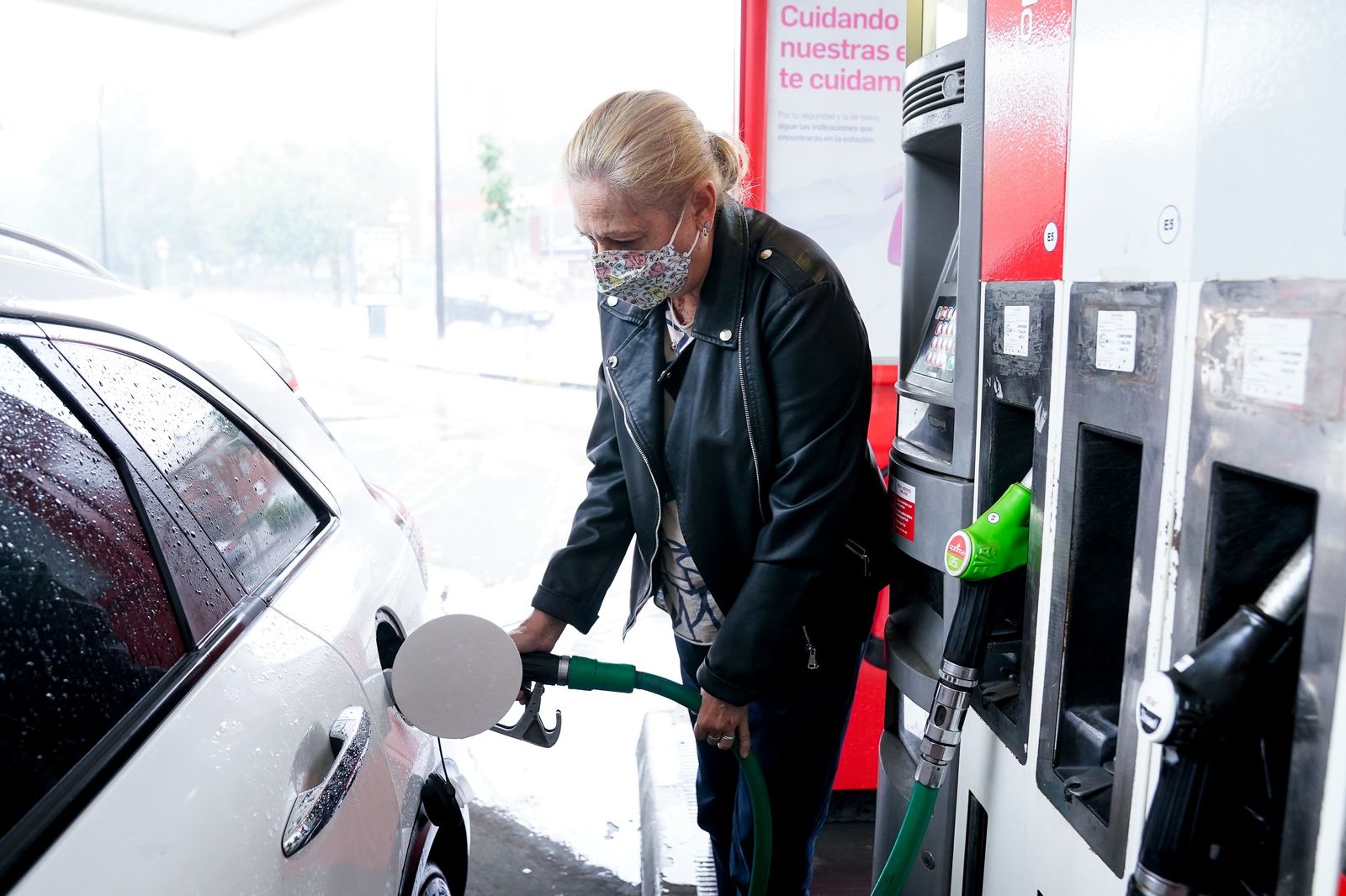 Una mujer reposta gasolina en una gasolinera