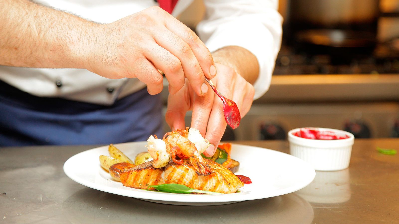 Un cocinero prepara un plato de salmón