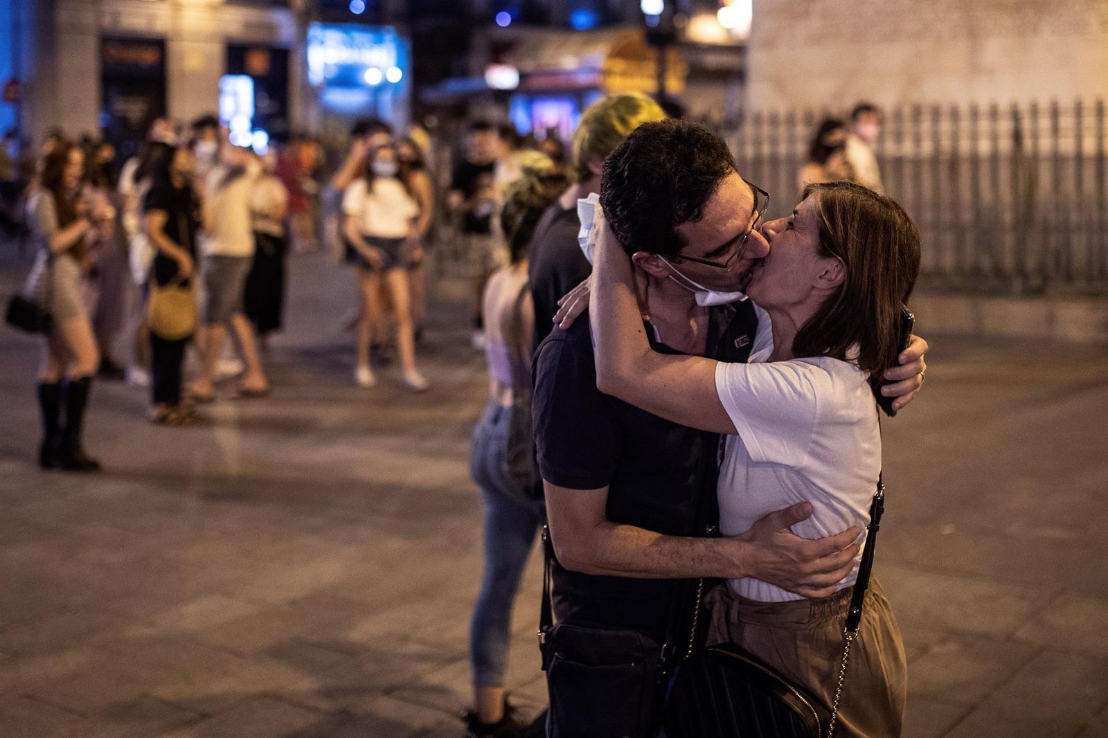 Un pareja celebra el fin del uso obligatorio de mascarillas en exteriores en la Puerta del Sol