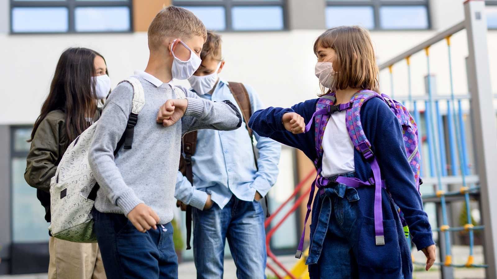 Niños saludándose con el codo