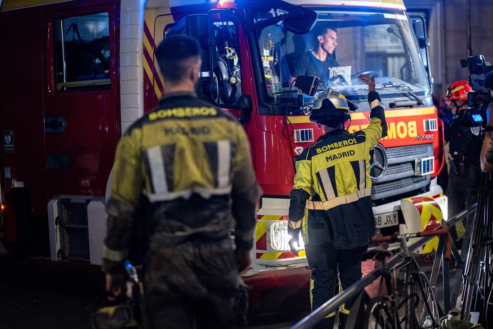 Varios bomberos de Madrid trabajan durante la noche en el rescate de las víctimas del derrumbe en la calle de las Hileras 4