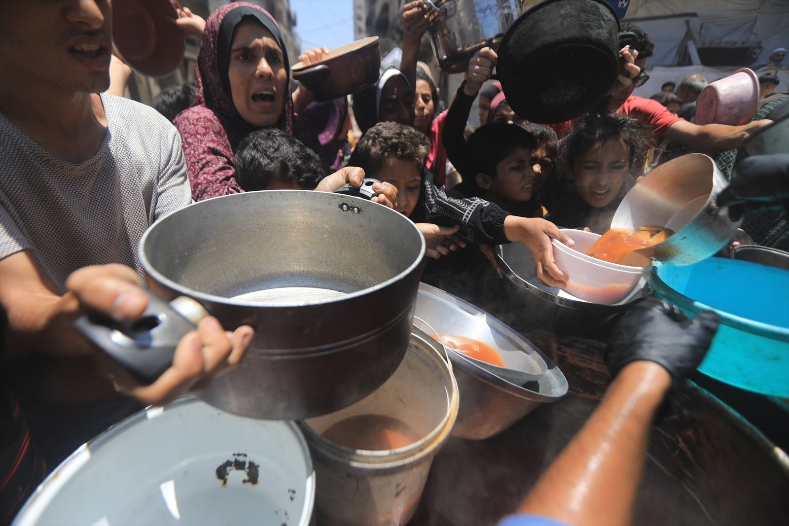 Un grupo de personas se agolpa en un punto de alimentación, en la Franja de Gaza