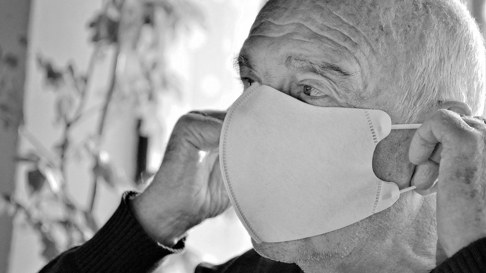 Un hombre mayor se coloca la mascarilla