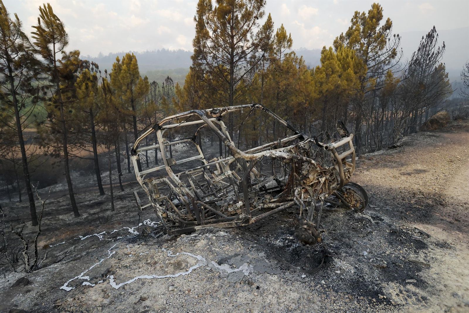 Un vehículo calcinado tras el paso del fuego en el incendio de Bejís, en Castellón