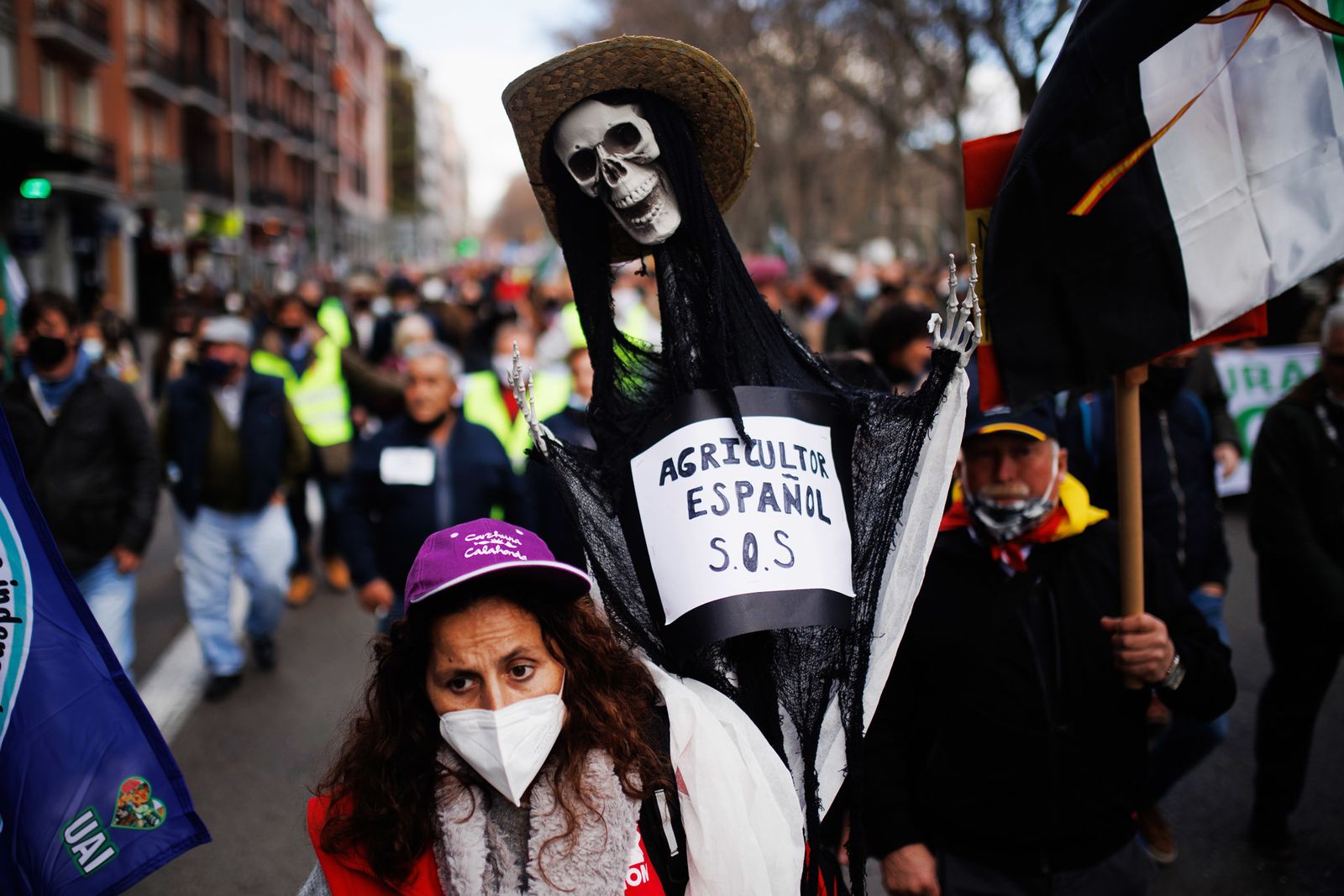 Una manifestante con un esqueleto con una pancarta que reza, Agricultor español S.O.S.