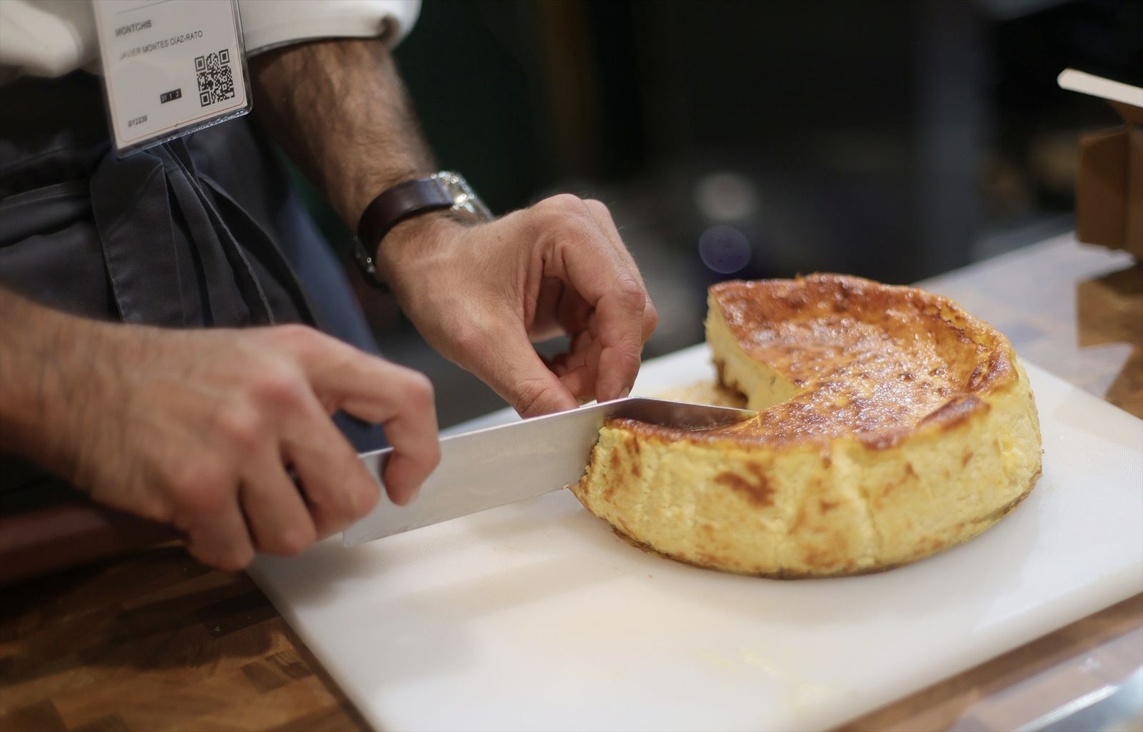 Un camarero corta una porción de tarta de queso