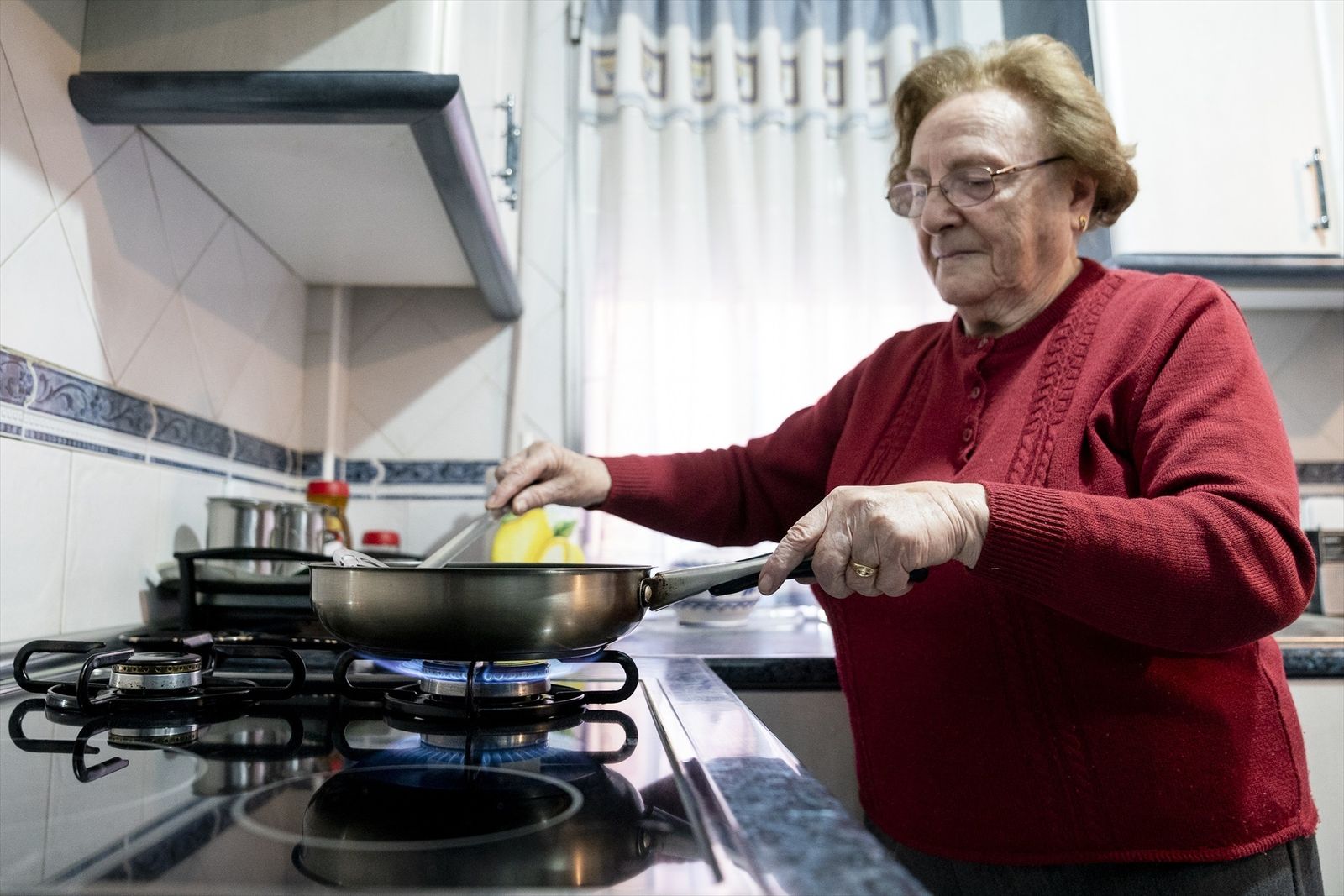 Una mujer prepara comida sobre un fuego de cocina