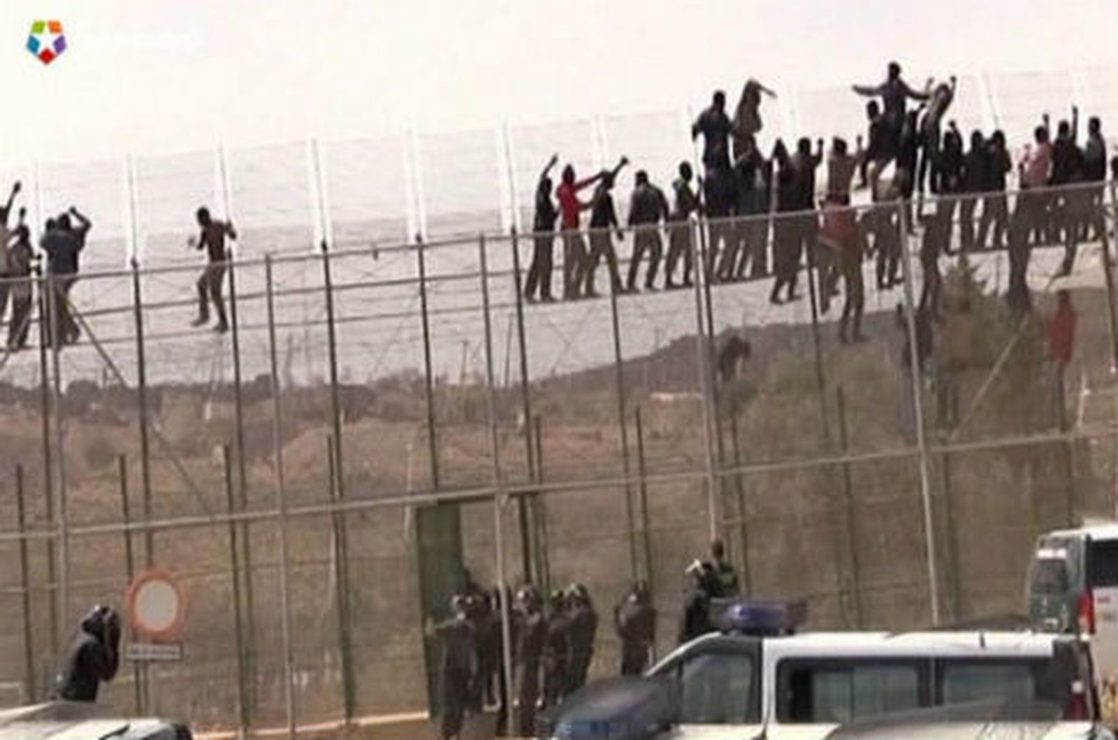 Encaramados a la valla de Melilla
