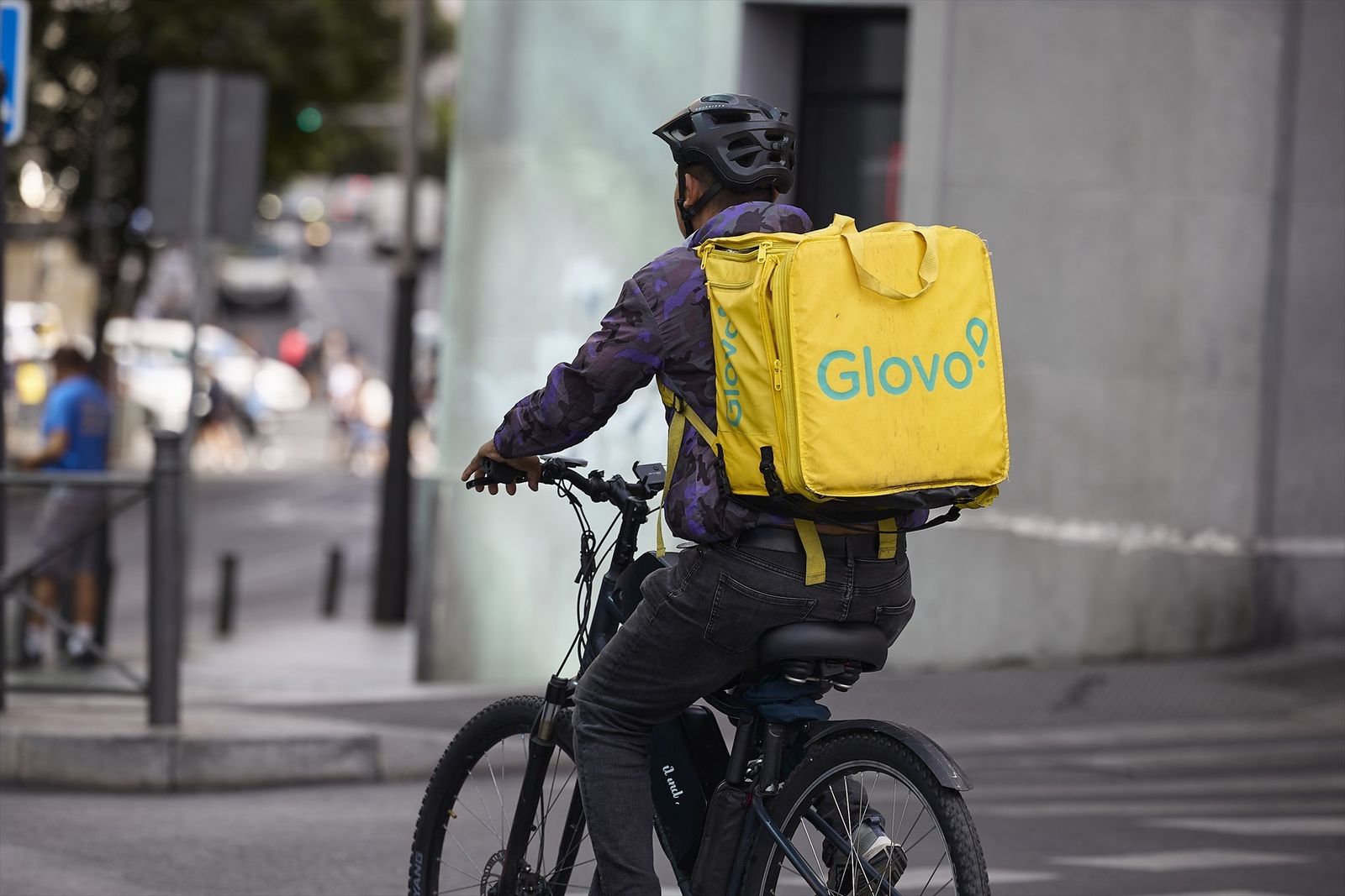 Un repartidor de Glovo en bicicleta por una calle de Madrid