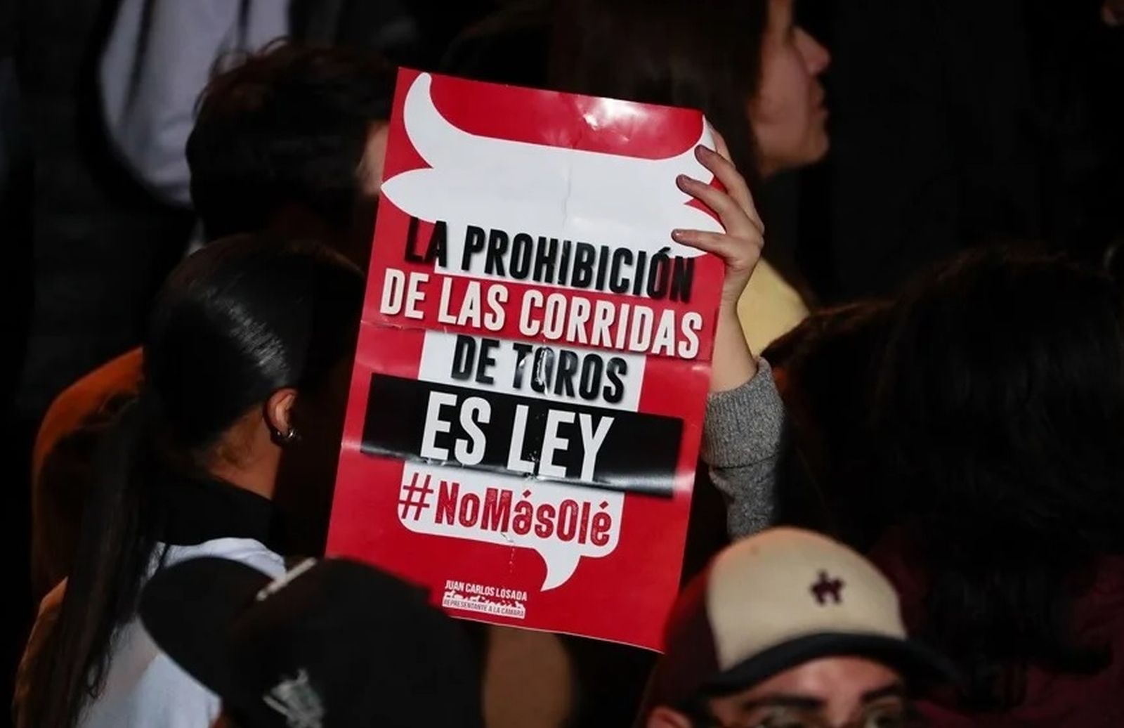 Un hombre sostiene un cartel de apoyo a la prohibición de las corridas de toros en Colombia