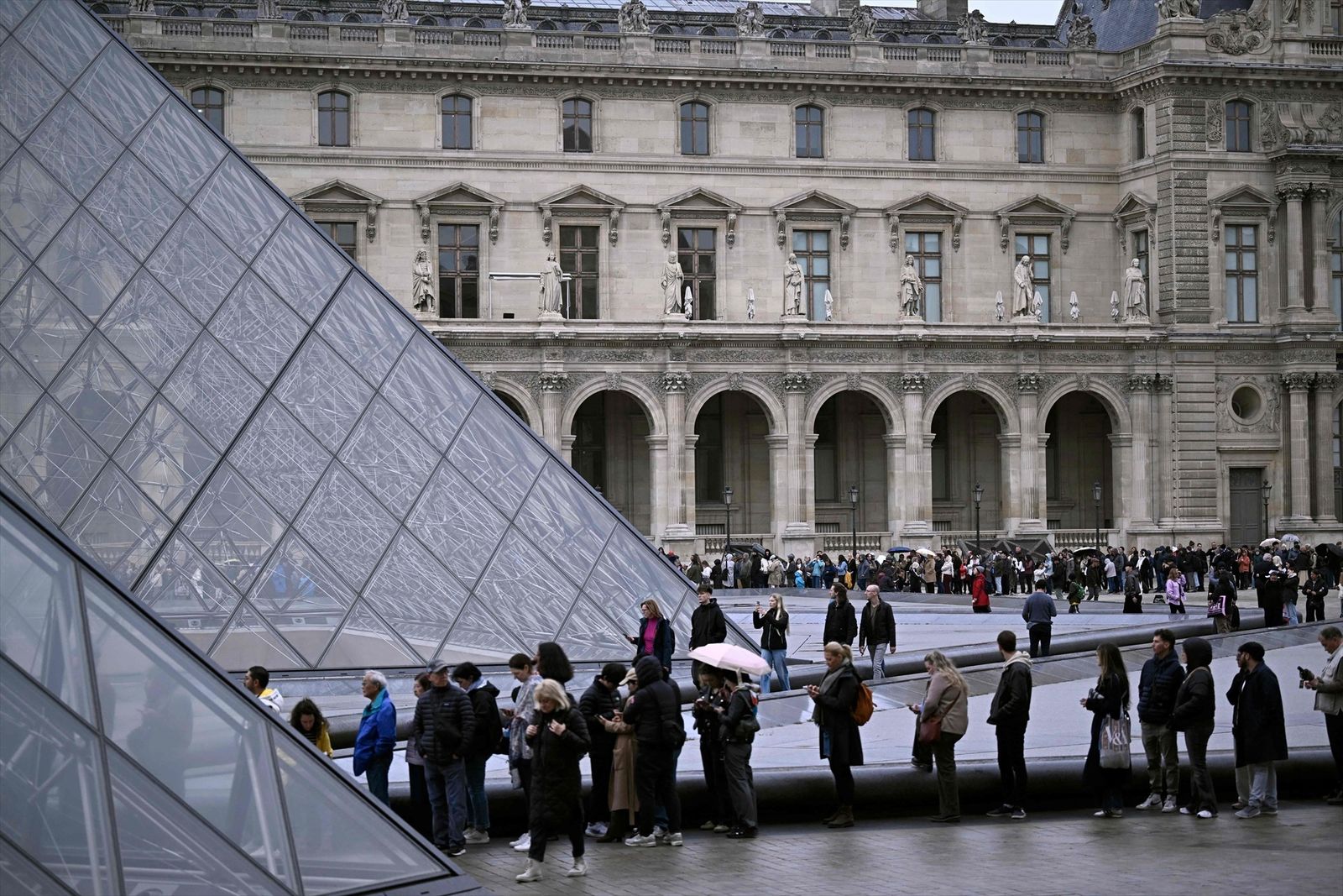 Personas haciendo cola para entrar al Museo del Louvre de París