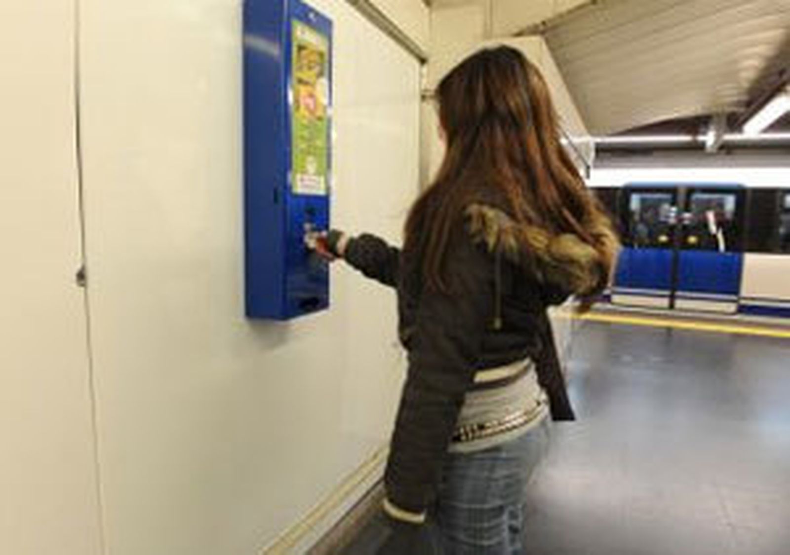 Una mujer saca un preservativo en el Metro