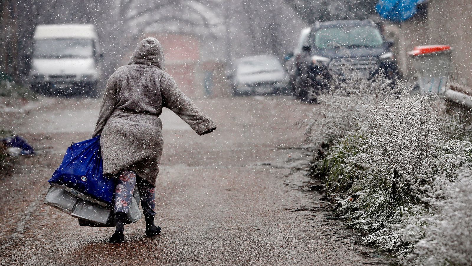 Una vecina de la Cañada Real camina bajo la nieve