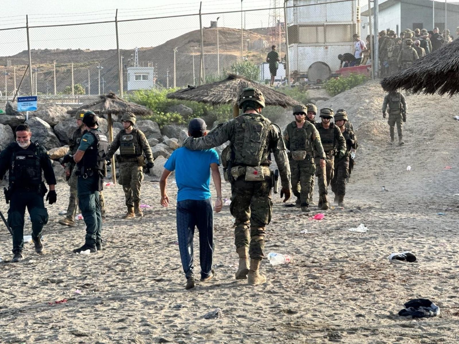 Un militar acompaña a un joven inmigrante en Ceuta