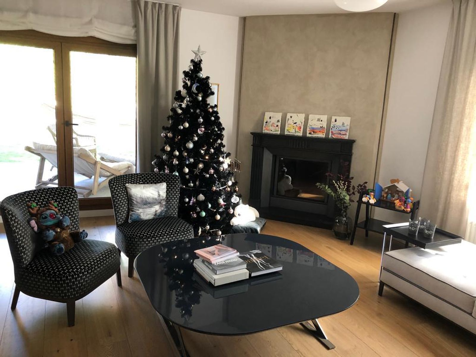 Este es el salón de una enorme casa de La Moraleja. Con su chimenea, un árbol de Navidad negro y un pequeño belén artesanal .