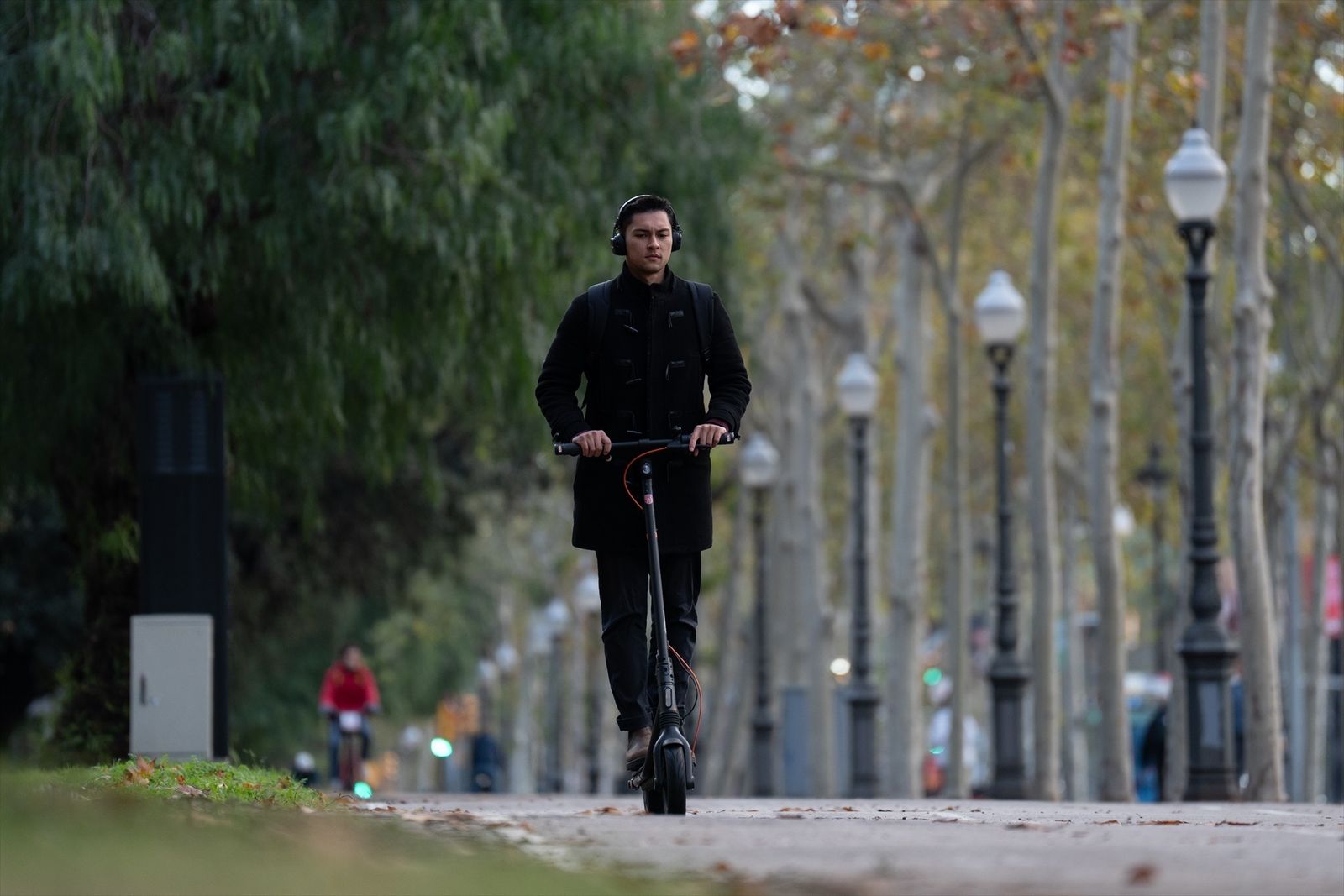 Una persona en patinete circulando con ariculares
