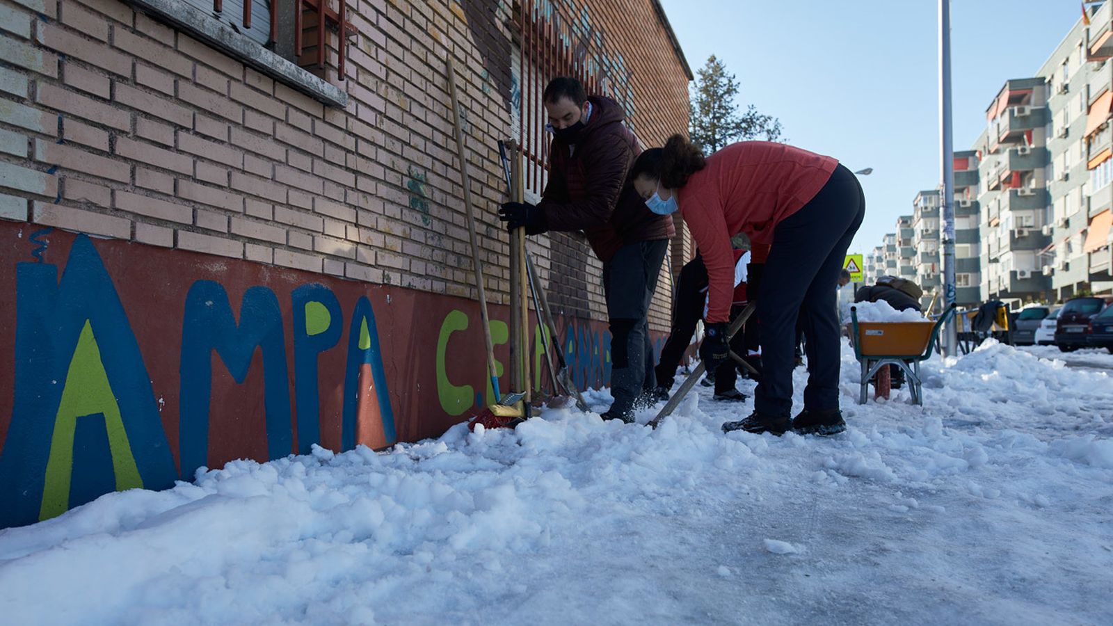 Padres de alumos ayudan a retirar nieve de los exteriores de un colegio de Madrid