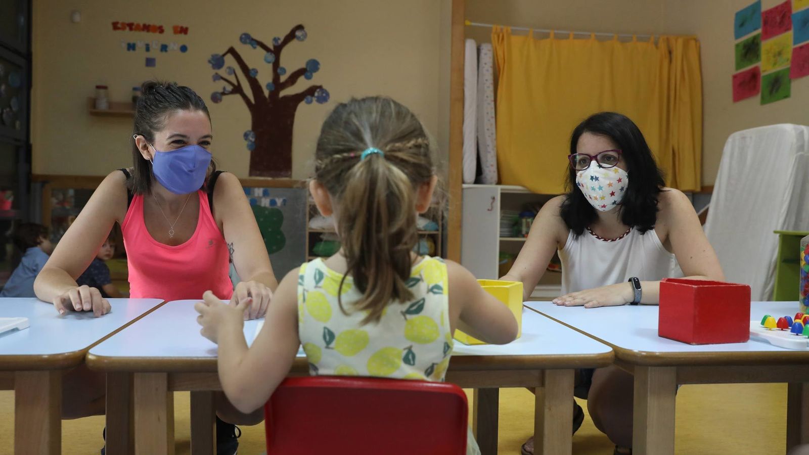 Dos profesoras atienden a una alumna de infantil en una escuela de Madrid