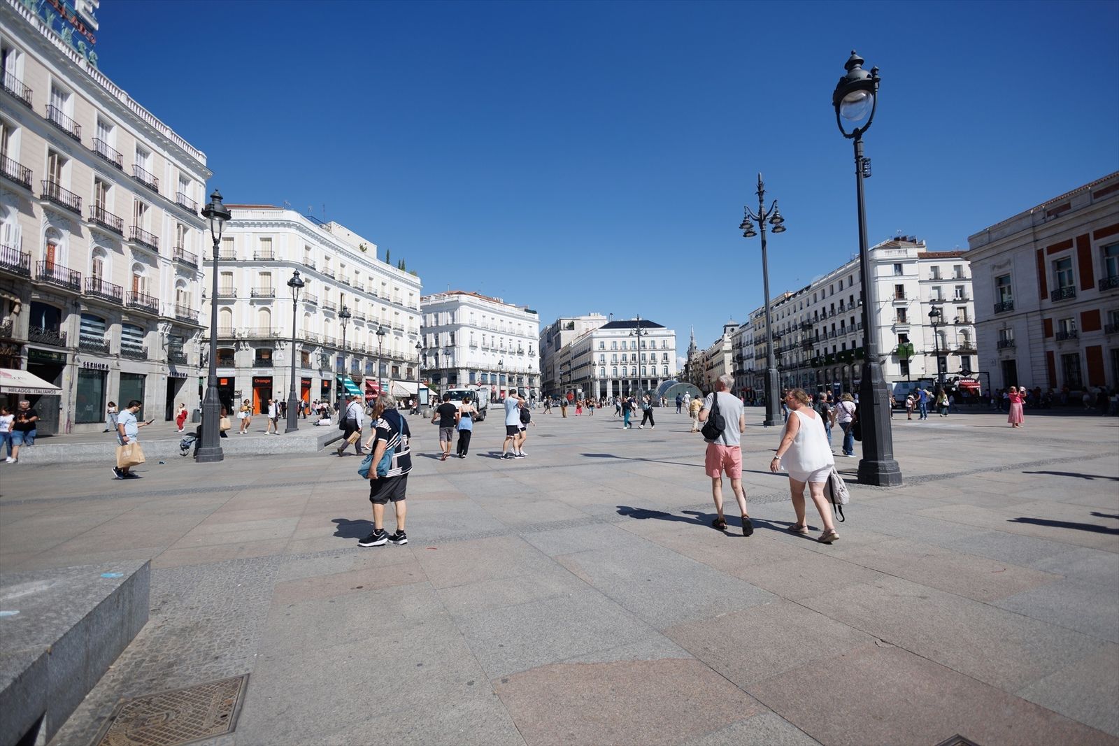 Personas caminan por la Puerta del Sol