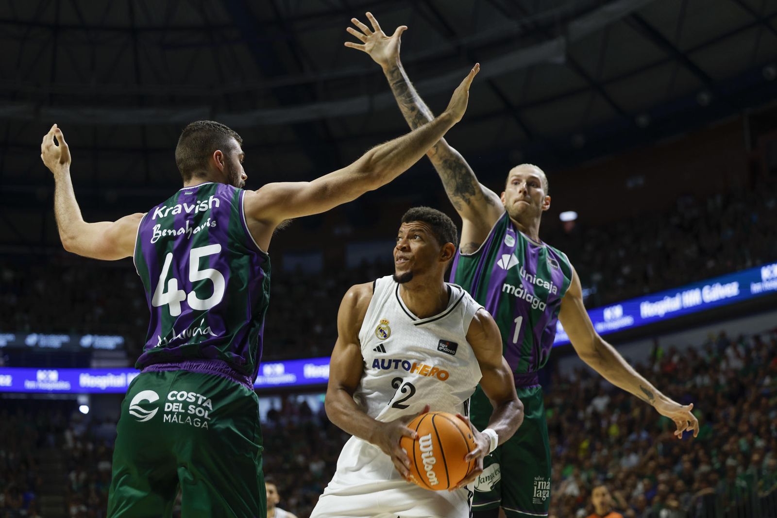 El madridista Edy Tavares, ante dos jugadores del Unicaja