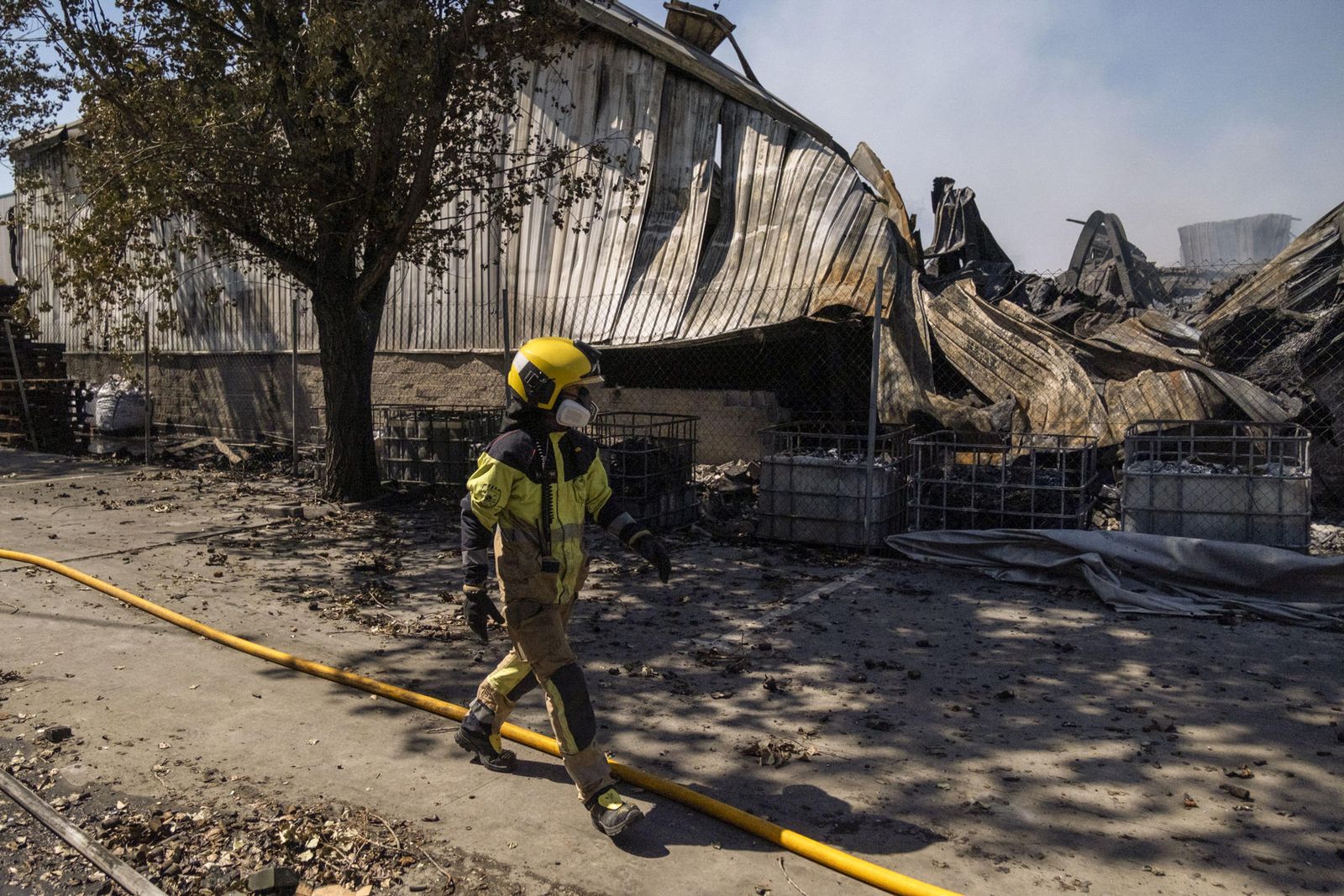 Un bombero inspecciona el exterior de la nave siniestrada en Azuqueca de Henares