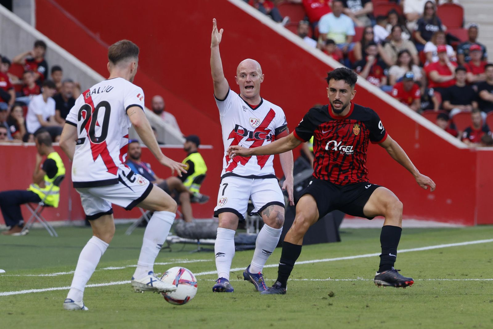 El delantero del Rayo Vallecano, Isi Palazón (c) pide la pelota a su compañero Iván Balliu (i)