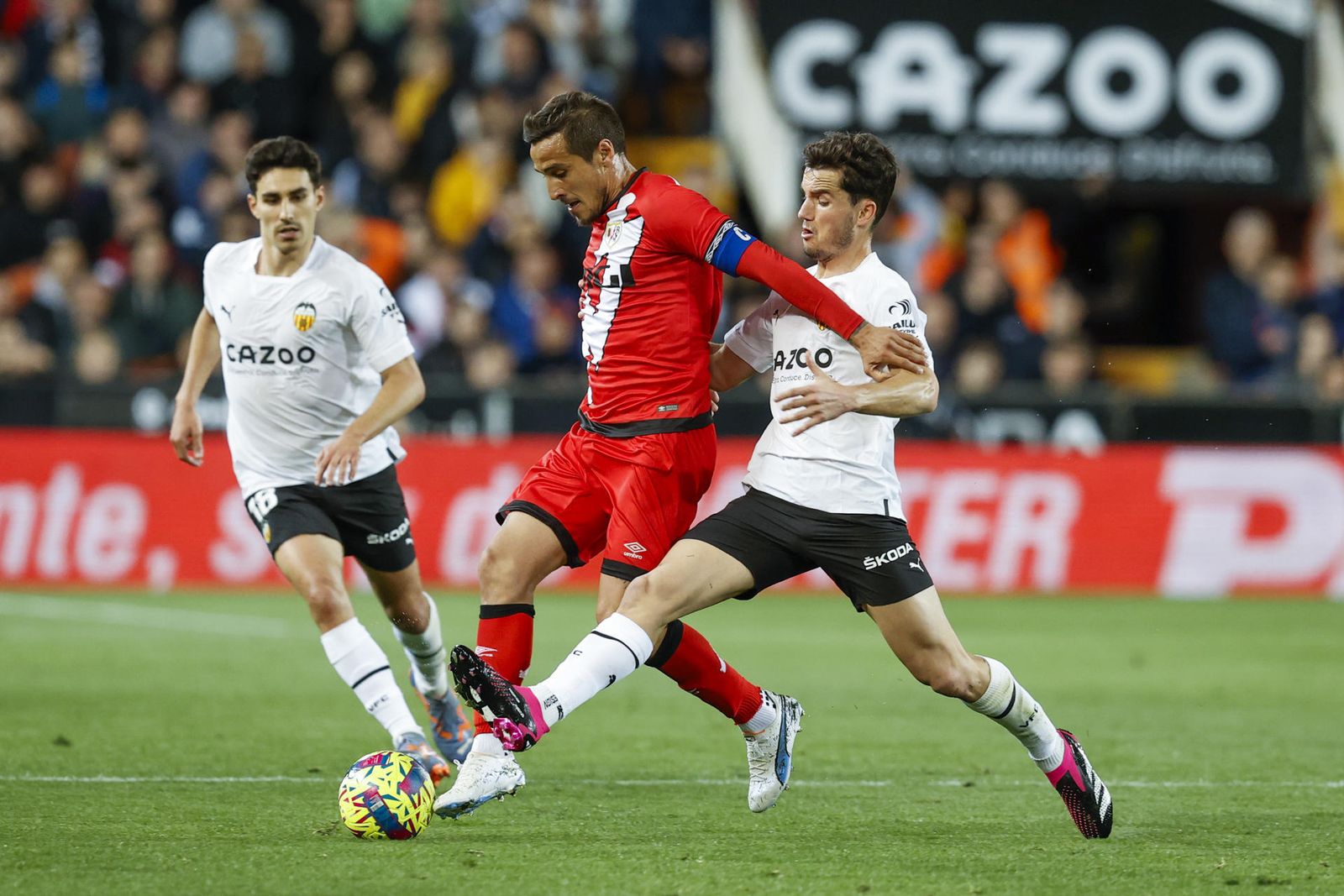 El delantero argentino del Rayo Vallecano, Óscar Trejo, intenta llevarse el balón ante el defensa del Valencia, Hugo Guillamón