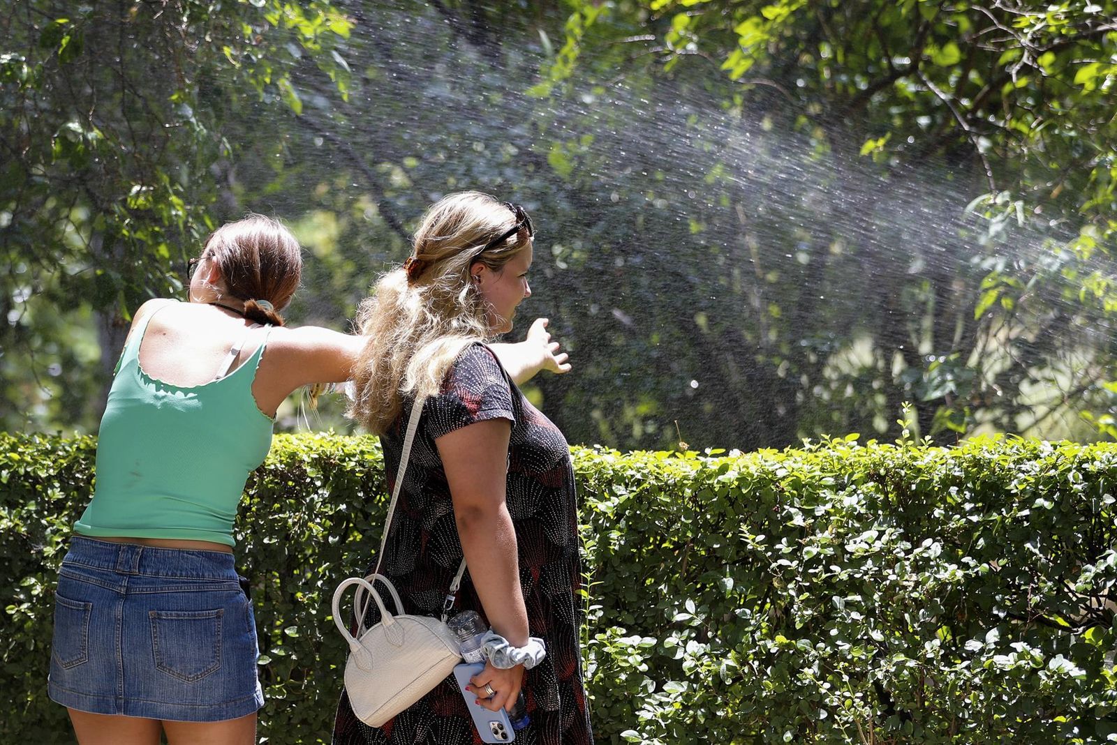 Unas mujeres se refrescan en Madrid por la ola de calor