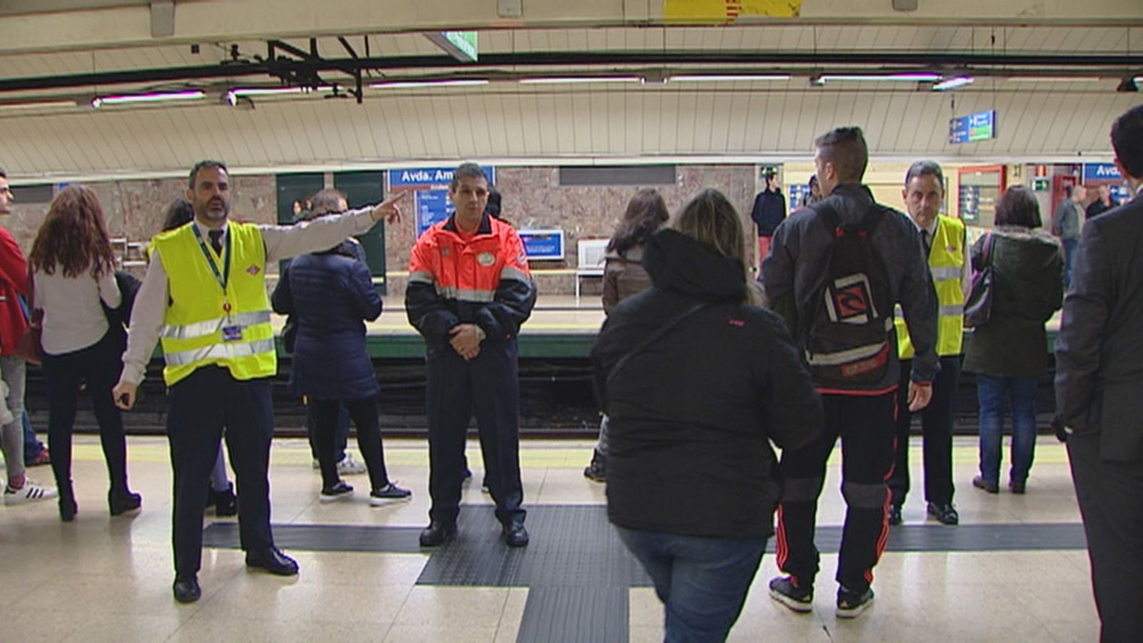 Empleados de Metro de Madrid dan instrucciones a los viajeros en el andén